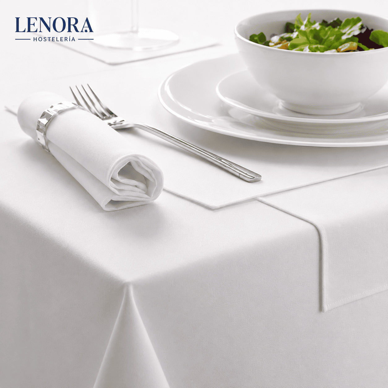 Mesa de restaurante vestida con mantel blanco de satén, servilleta y cubiertos
