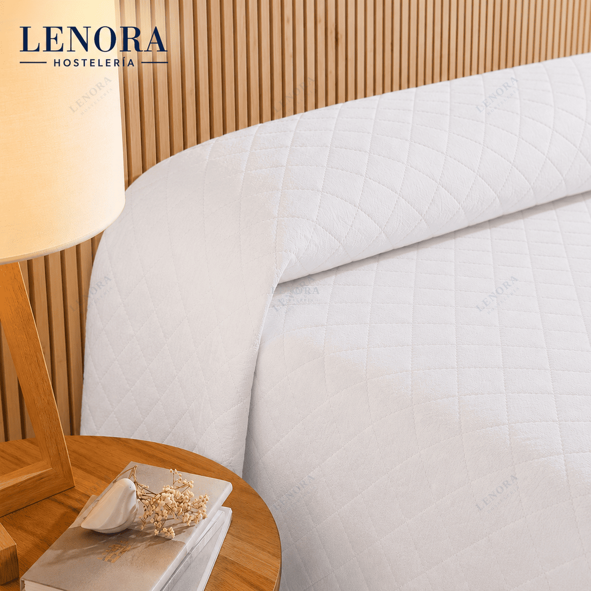 Cama de hotel vestida con colcha de rombos blanca