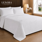 Habitación de hotel con cama vestida con colcha de rombos
