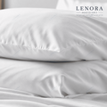 Fundas de almohada blancas apiladas sobre cama de hotel