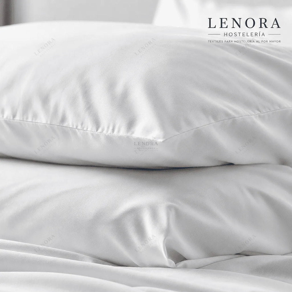 Fundas de almohada blancas apiladas sobre cama de hotel