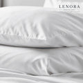 Fundas de almohada blancas apiladas sobre cama de hotel