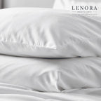 Fundas de almohada blancas apiladas sobre cama de hotel