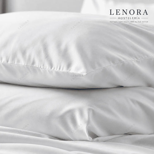 Fundas de almohada blancas apiladas sobre cama de hotel