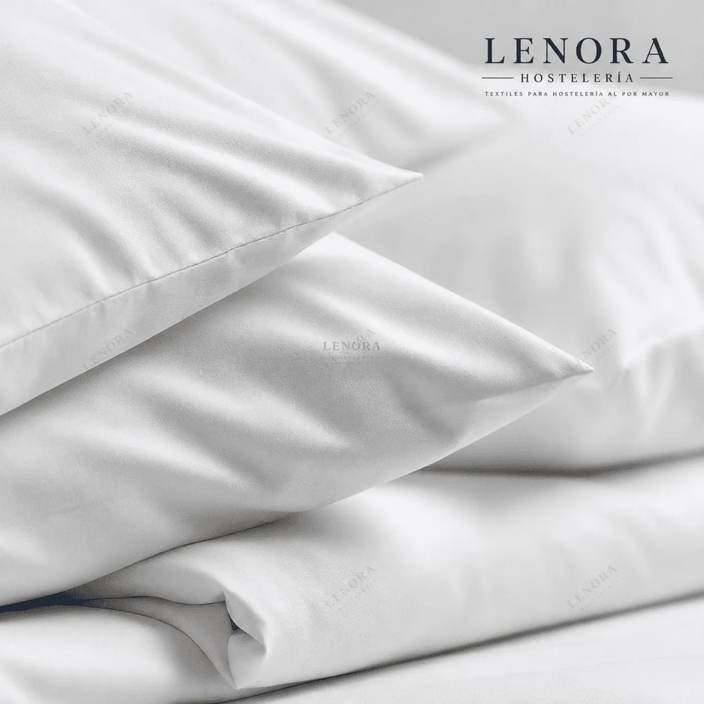 Funda de almohada blanca colocada sobre cama vestida