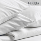 Funda de almohada blanca colocada sobre cama vestida