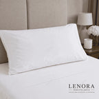 Almohada blanca de hotel colocada sobre una cama vestida