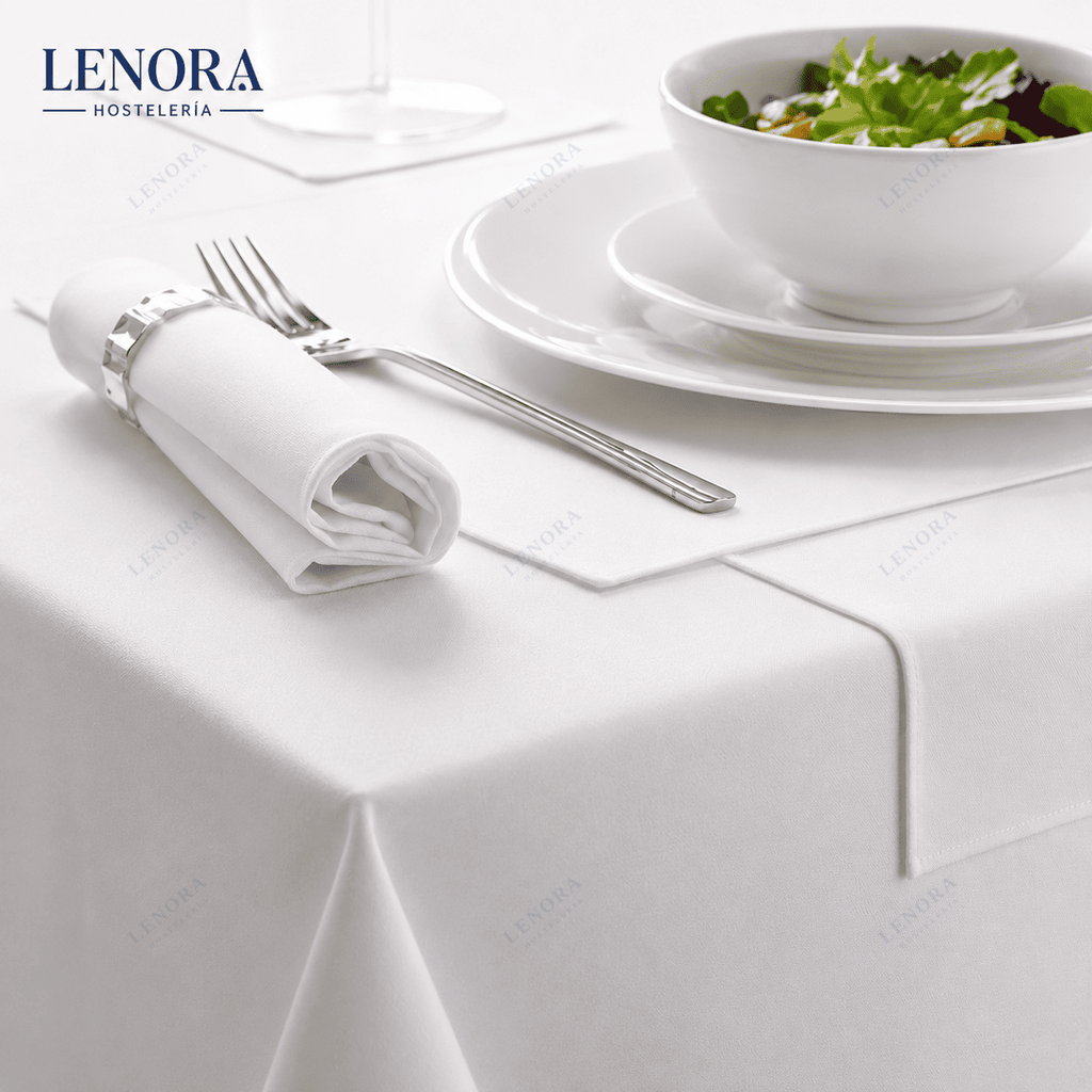 Mesa de restaurante vestida con mantel de satén blanco, servilleta y cubiertos