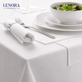 Mesa de restaurante vestida con mantel de satén blanco, servilleta y cubiertos