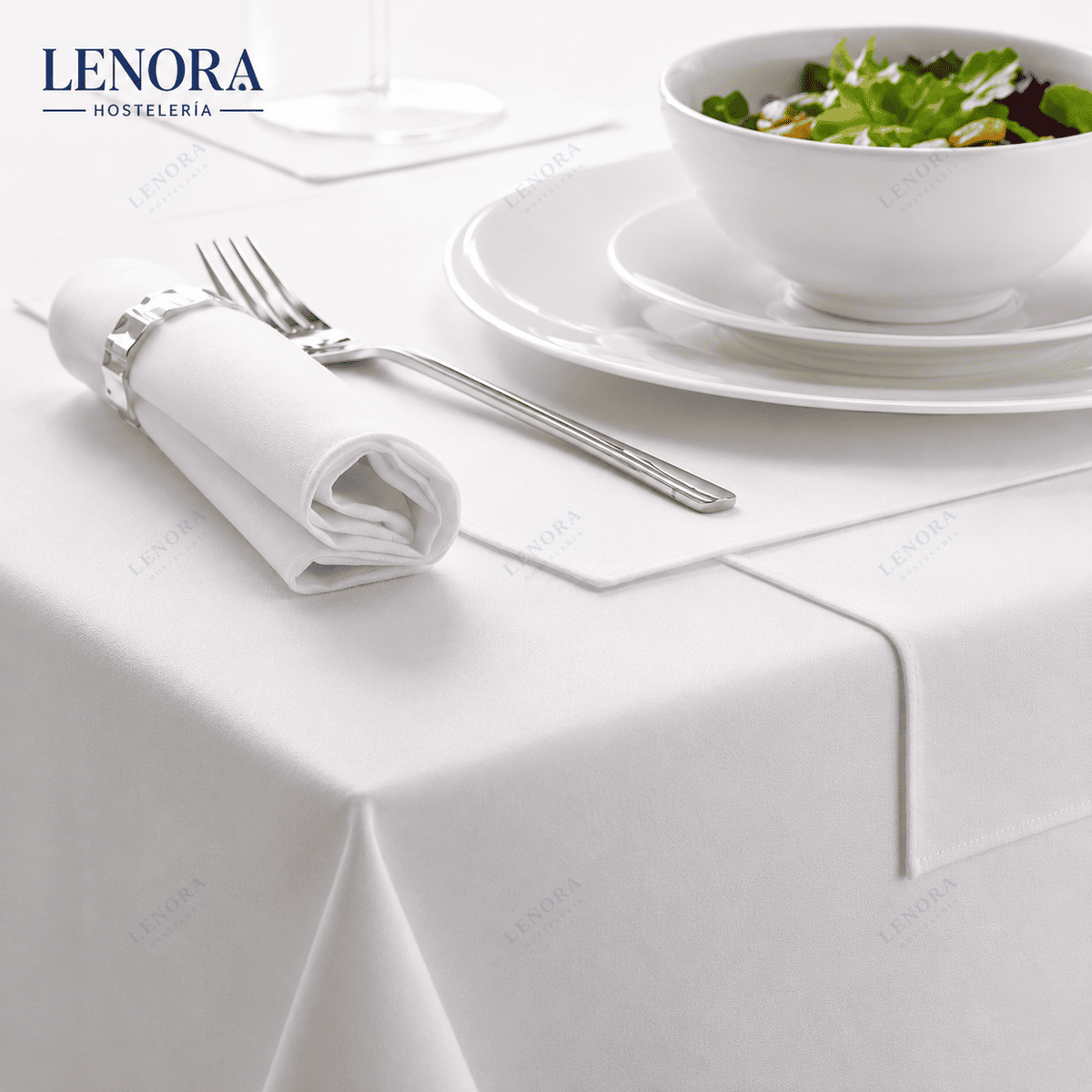 Mesa de restaurante vestida con mantel de satén blanco, servilleta y cubiertos
