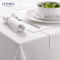 Mesa de restaurante vestida con mantel de satén blanco, servilleta y cubiertos