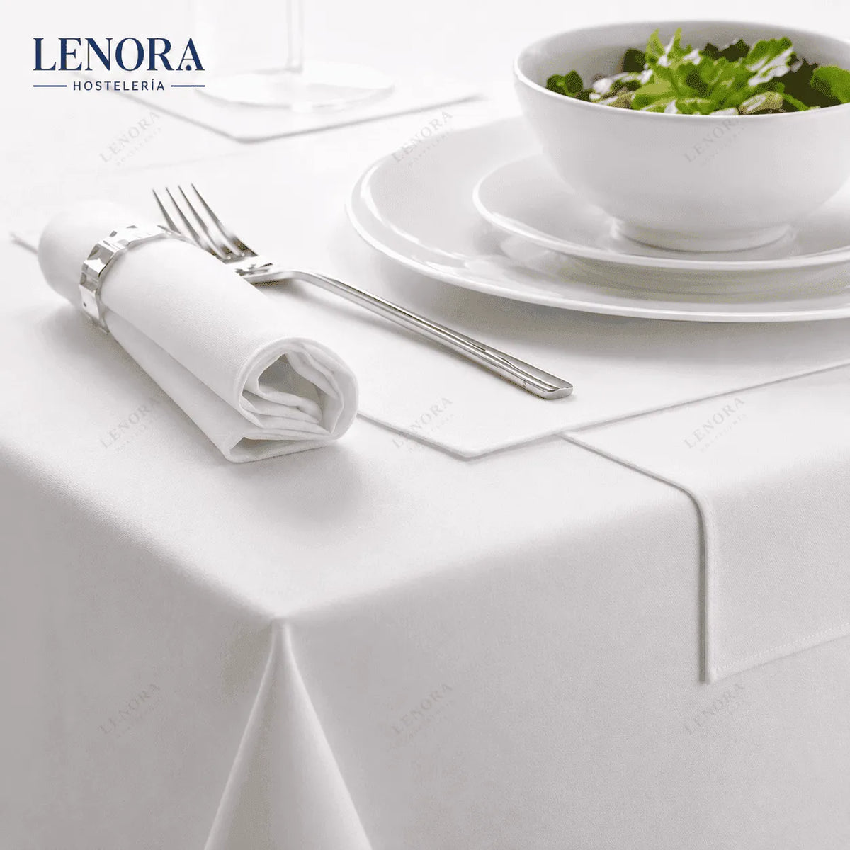 Mesa de restaurante vestida con mantel de satén blanco, servilleta y cubiertos