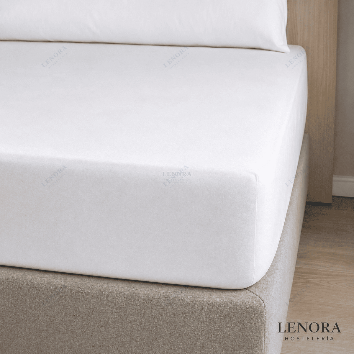 Sábana bajera ajustable blanca colocada sobre un colchón de hotel