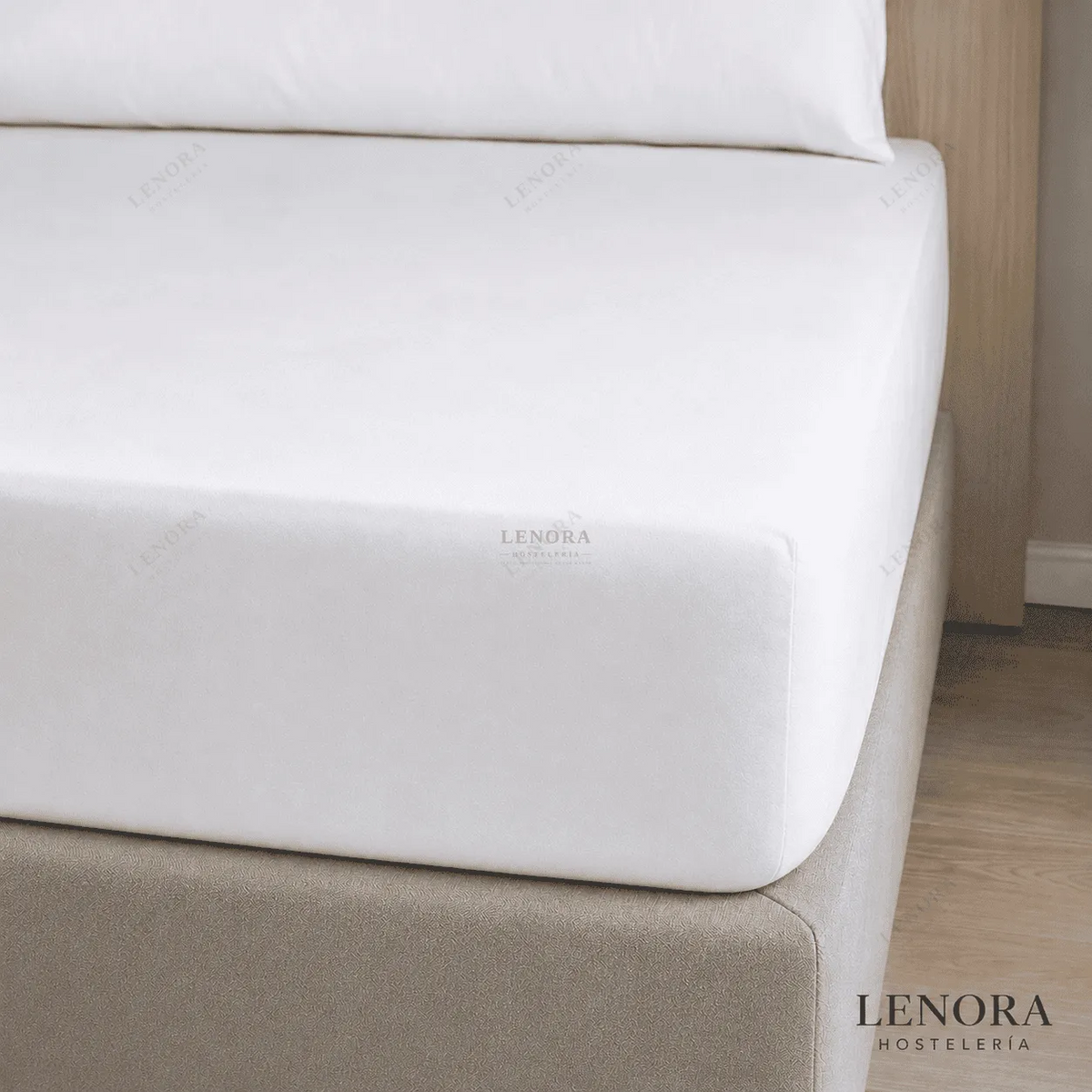 Sábana bajera ajustable blanca colocada sobre un colchón de hotel