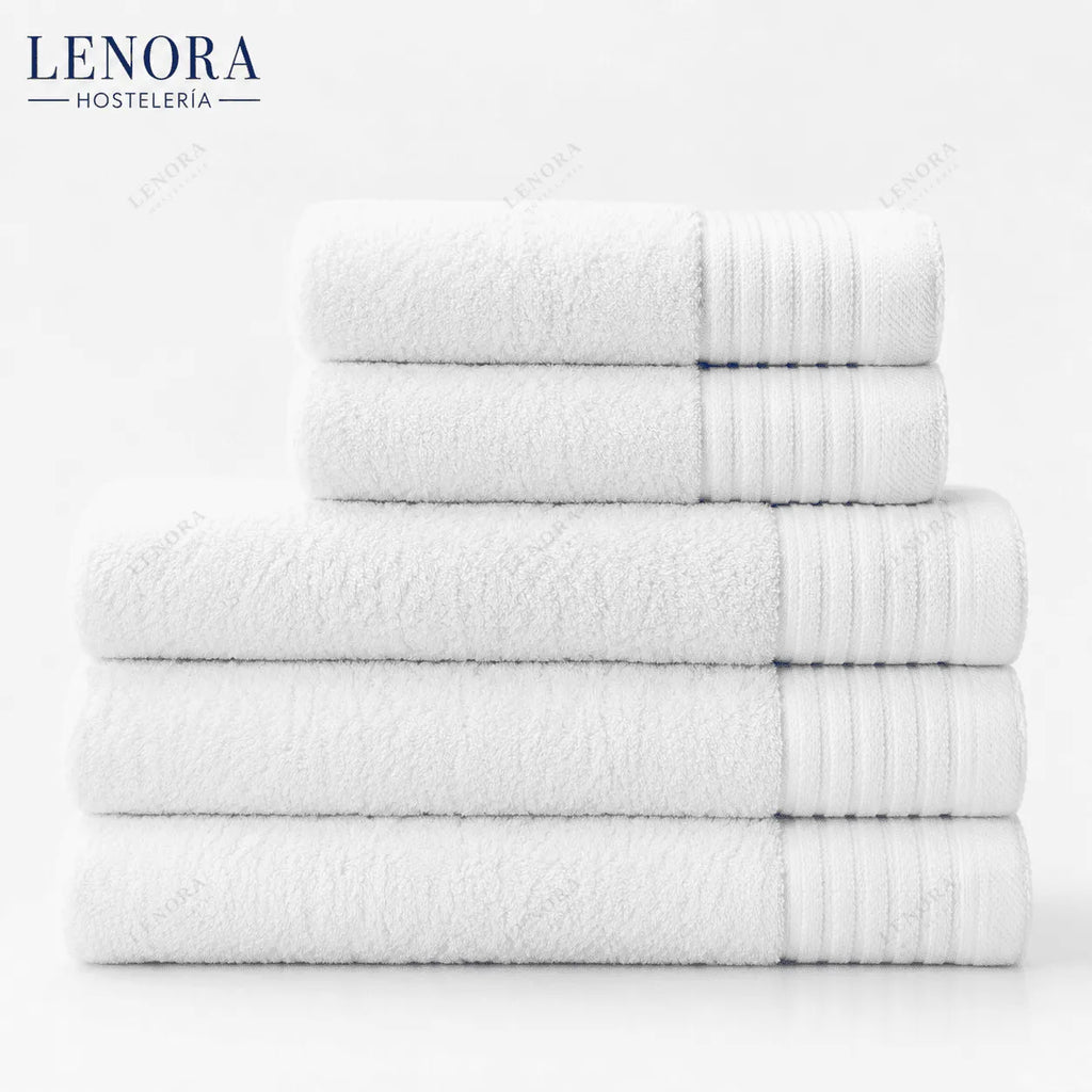 Toallas blancas de hotel apiladas por medidas del pack de baño