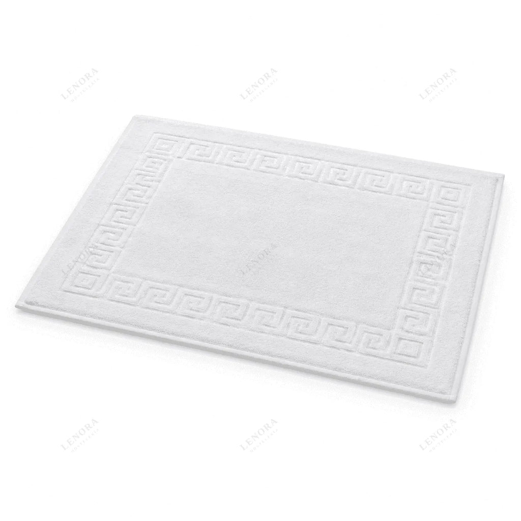 Alfombrín de baño blanco con greca visto de frente sobre fondo neutro
