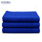 Alfombrines de baño azul Idanthren apilados con cenefa de greca