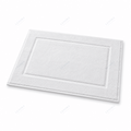 Alfombrín de baño blanco con relieve de rayas visto de frente