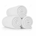 Alfombrines de baño blancos enrollados y apilados en pirámide