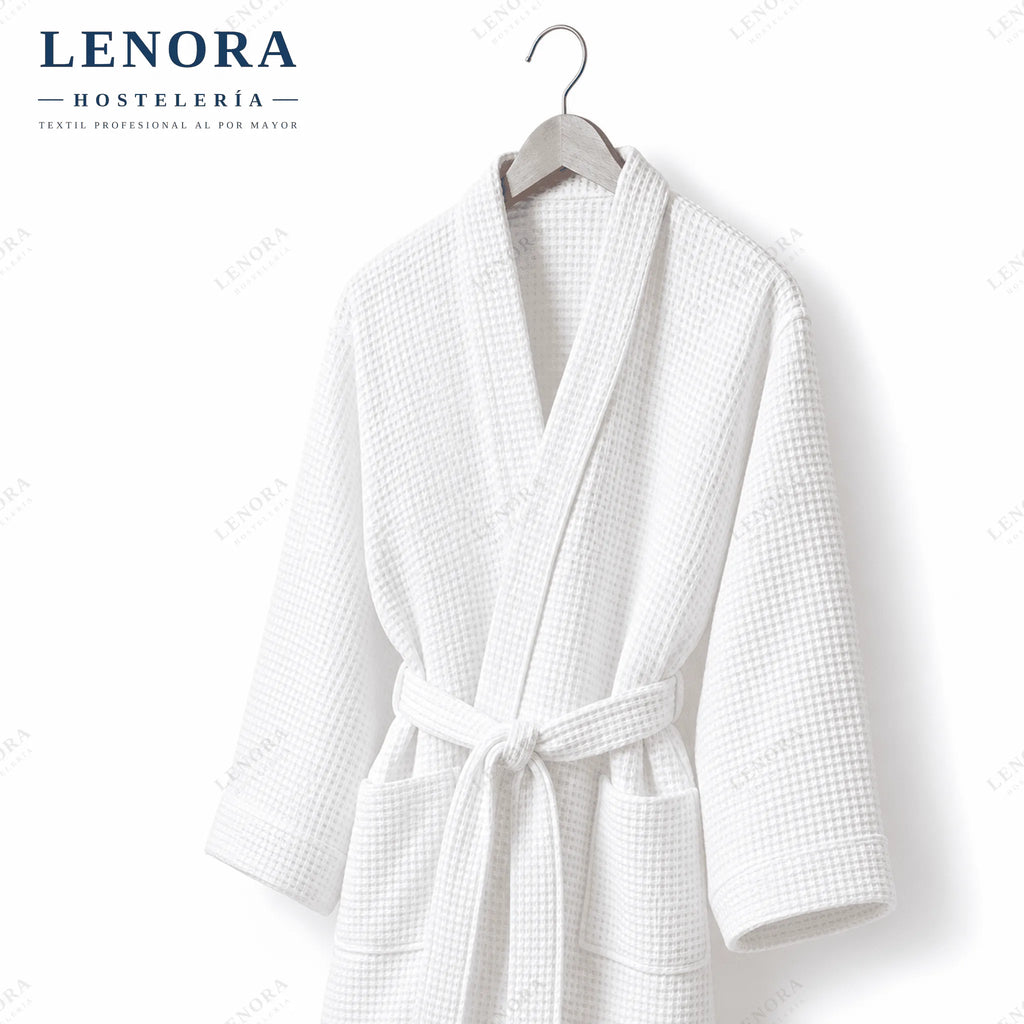 Albornoz blanco de nido de abeja colgado en percha de madera