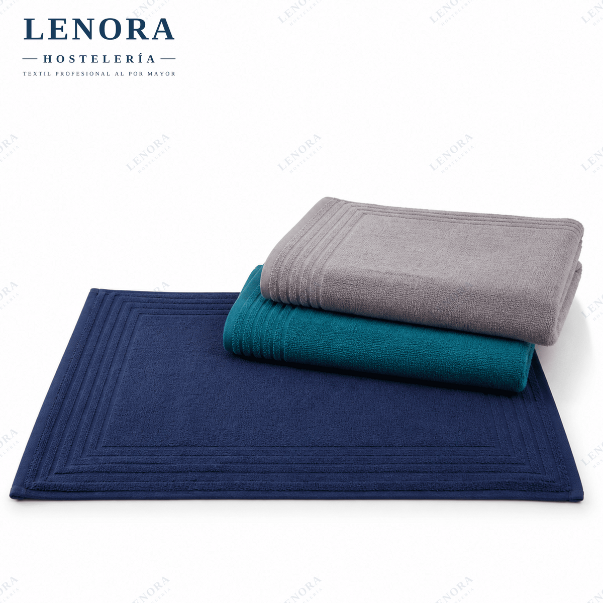Alfombrines de baño de color apilados en azul marino, turquesa y gris