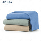 Colchas Girona dobladas en azul, verde salvia y beige